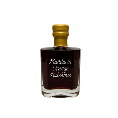A small clear glass bottle of Mandarin Orange Balsamic with a gold cap and white script text on the front, shown on a plain white background.