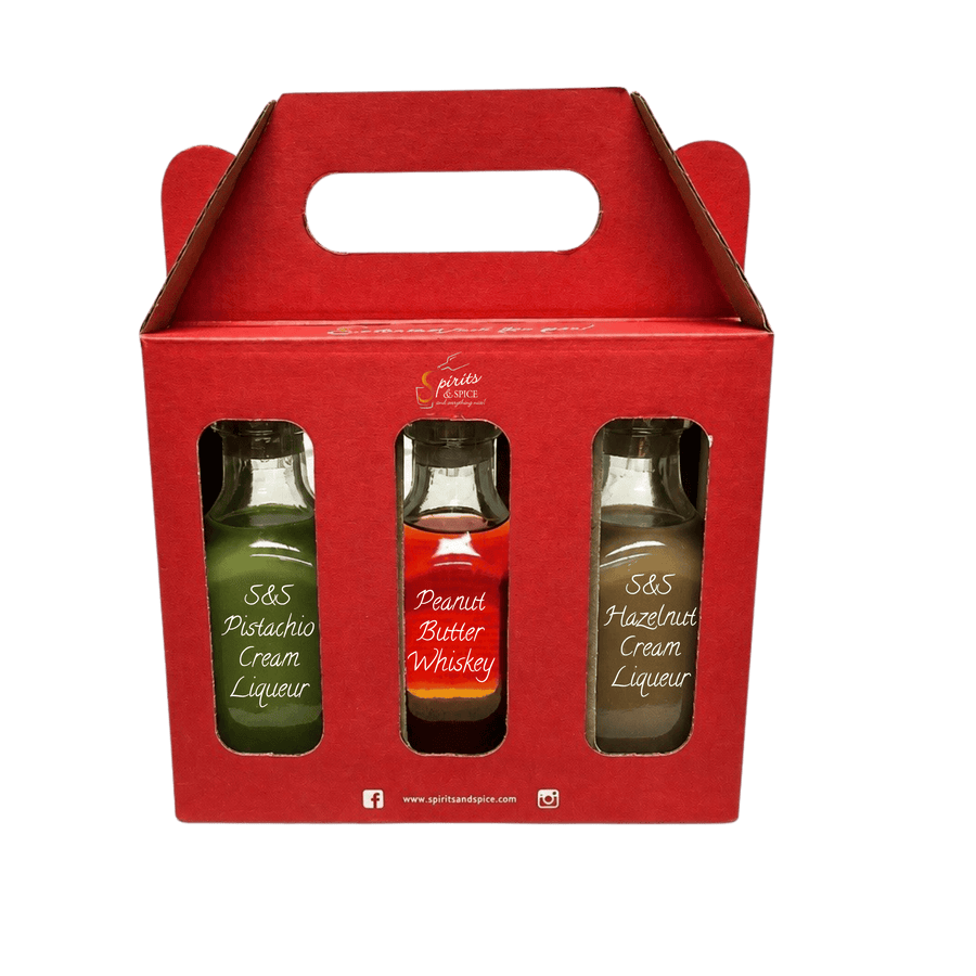 A red cardboard gift box with a handle, containing three small liquor bottles visible through cutout windows. The bottles are labeled S&S Pistachio Cream Liqueur, S&S Peanut Butter Whiskey, and S&S Hazelnut Cream Liqueur.