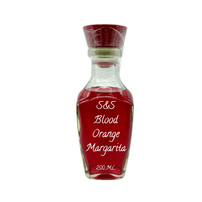 A small clear glass bottle filled with red liquid, featuring a dark red cap and a white printed label that reads 'S&S Blood Orange Margarita 200 ML'.