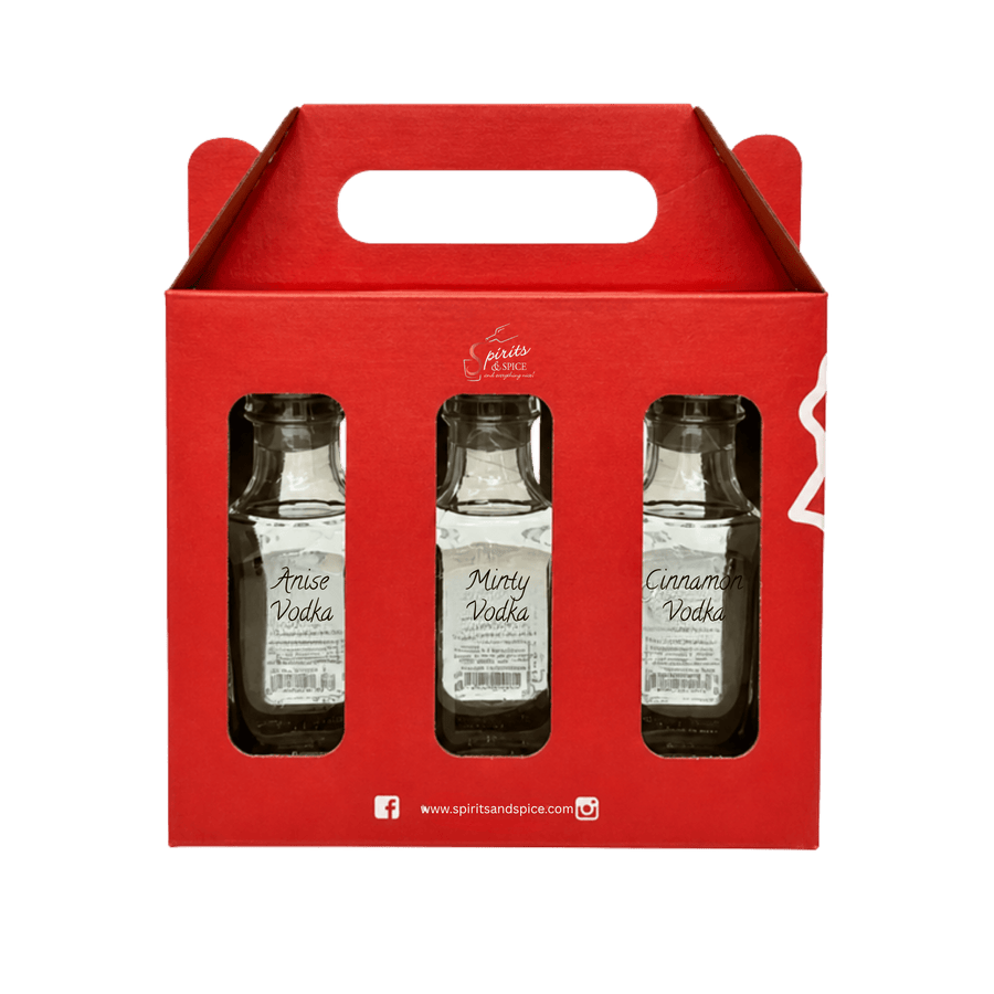 A red cardboard 3-pack carrier holding three small glass bottles of vodka: Anise Vodka, Minty Vodka, and Cinnamon Vodka. The carrier has a handle cutout and visible 'spiritsandspice' branding.